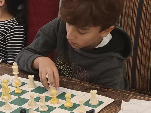Estudiante jugando en el club de ajedrez